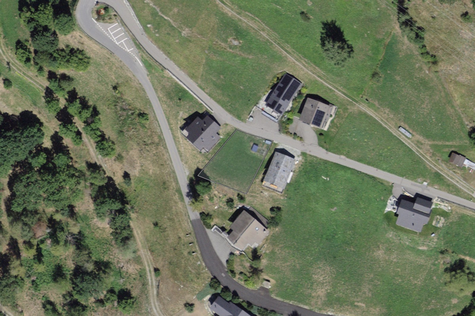 Orthophoto : la parcelle surlignée au milieu des chalets, le Chemin du Moulin et la Route des Mayens.